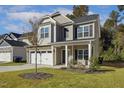Inviting two-story home with stone details, a two-car garage, and a pleasant front yard at 42 Chris Todd Way, Angier, NC 27501