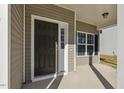 Close-up of a stylish black front door with sidelights and a covered porch at 42 Chris Todd Way, Angier, NC 27501