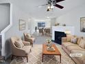Open living room with a fireplace, ceiling fan, neutral-toned furniture and a decorative rug at 4842 Wyatt Brook Way, Raleigh, NC 27609