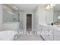 Elegant bathroom featuring a glass enclosed shower, a soaking tub, and a white vanity with double sinks and chrome fixtures at 5036 Trotter Dr, Raleigh, NC 27603