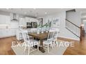 Bright dining area with a wooden table, white chairs, and views into the modern kitchen with stainless steel appliances at 5036 Trotter Dr, Raleigh, NC 27603