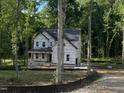 Two-story home under construction, showcasing a covered front porch and a partially wooded lot at 5036 Trotter Dr, Raleigh, NC 27603