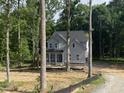 Charming new construction with vertical siding, covered porch, and picturesque wooded setting at 5036 Trotter Dr, Raleigh, NC 27603