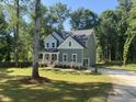 Charming two-story home with a welcoming front porch and well-manicured lawn in a serene, wooded setting at 5036 Trotter Dr, Raleigh, NC 27603