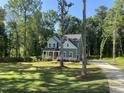 Two-story home with welcoming front porch and well-manicured lawn, surrounded by a tranquil wooded area at 5036 Trotter Dr, Raleigh, NC 27603