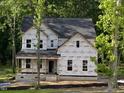 Close up of a two-story home under construction featuring a covered front porch and large windows at 5036 Trotter Dr, Raleigh, NC 27603