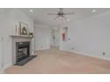 Cozy living room with neutral paint, carpet flooring, a ceiling fan, and a fireplace at 534 Ives Ct, Chapel Hill, NC 27514