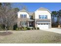 Attractive two-story home featuring a stone facade, two car garage, and well-maintained lawn at 5421 Downton Grove Ct, Fuquay Varina, NC 27526