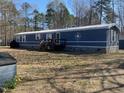 Quaint one-story home featuring blue siding, a wooden porch, and a well-maintained front yard at 55 Waters Edge Loop, Henderson, NC 27537