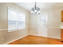Bright dining area with hardwood floors, a modern light fixture, and access to the backyard at 5717 Woof Pl, Knightdale, NC 27545