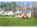 Well-maintained home with a green lawn and mature trees in a peaceful neighborhood at 5717 Woof Pl, Knightdale, NC 27545