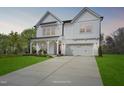 Beautiful two-story farmhouse featuring a well-manicured lawn and concrete driveway at 69 Alex Farm Ct # 21, Zebulon, NC 27597