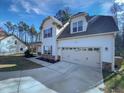 Inviting home featuring a two-car garage, covered porch, and beautifully maintained lawn at 69 Azul Dr, Clayton, NC 27520