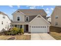Charming two-story home boasts a well-maintained front yard and an attached two-car garage at 717 Tailrace Falls Ct, Wake Forest, NC 27587