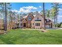 Expansive front lawn leads to a beautiful brick home surrounded by mature trees at 1001 Welch Ln, Raleigh, NC 27614