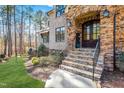Stone steps lead to an elegant entryway with a dark wood door and stone surround at 1001 Welch Ln, Raleigh, NC 27614