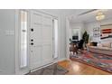 Bright foyer with white front door, view of hardwood floors, and adjacent living area at 101 Weatherly Pl, Cary, NC 27518