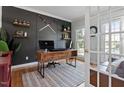 Stylish home office with a dark accent wall, hardwood floors, and natural light at 101 Weatherly Pl, Cary, NC 27518