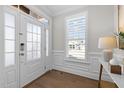 Bright foyer features detailed trim work, transom window, sidelights, and hardwood floors at 1013 Manchaca Loop, Apex, NC 27539