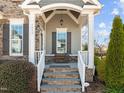 Inviting stone front porch with bench seating and craftsman-style architectural details at 1013 Manchaca Loop, Apex, NC 27539