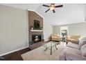 Inviting living room features a brick fireplace, plush seating, and a ceiling fan for added comfort at 103 Willoughby Ln, Cary, NC 27513