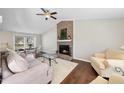 Open-concept living and dining area with vaulted ceiling, brick fireplace, and seamless flow at 103 Willoughby Ln, Cary, NC 27513