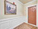 Well-lit hallway with elegant wainscoting, decorative painting, and stylish flooring creating an inviting transition space at 10421 Rosegate Ct # 303, Raleigh, NC 27617
