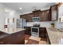 Well-equipped kitchen featuring dark wood cabinets, stainless steel appliances, and granite countertops at 1055 Kerr St, Burlington, NC 27215