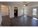 Bright living room with high ceilings, ceiling fan, and modern dark wood flooring at 1104 Thelonious Dr, Raleigh, NC 27610