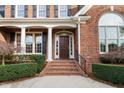 Inviting front entrance with brick steps, decorative columns, and an elegant wooden door at 112 Trellingwood Dr, Morrisville, NC 27560