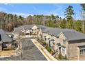 An aerial view showcases a neighborhood of well-maintained brick townhomes and lush trees at 138 Tressel Way, Durham, NC 27707