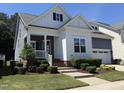 Lovely two-story home featuring a welcoming porch and neatly trimmed shrubs against a clear blue sky at 1564 Highpoint St, Wake Forest, NC 27587