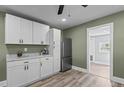 Kitchen featuring stainless steel refrigerator, white cabinets and hardware, and wooden floors at 1855 W West River Rd, Franklinton, NC 27525