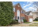 Attractive brick home with a two-car garage, manicured landscaping, and inviting front entrance at 205 Quarryrock Rd, Holly Springs, NC 27540