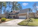 Attractive brick home with attached garage, a charming front porch, and well-manicured landscaping at 207 Lewey Brook Dr, Cary, NC 27519