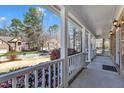 Inviting front porch features white railings, columns, and lush landscaping with flowering bushes at 207 Lewey Brook Dr, Cary, NC 27519