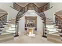 A grand foyer features dual staircases, elegant iron railings, and a marble floor at 212 Whirlaway Ln, Chapel Hill, NC 27516