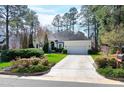 Inviting home with a clean driveway and a well-maintained lawn, surrounded by mature trees at 218 Whisperwood Dr, Cary, NC 27518