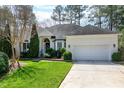 Traditional home with a well-manicured lawn, two-car garage, and elegant landscaping at 218 Whisperwood Dr, Cary, NC 27518