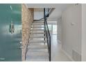 Bright entryway with a tiled floor, brick accent wall, staircase with a black railing at 220 Elizabeth St # B5, Chapel Hill, NC 27514