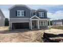 Two-story home with gray siding, stone accents, an attached two-car garage, and an unfinished front yard at 230 Tidal Pool Way, Cary, NC 27519