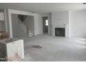 Spacious open-concept living room with a fireplace and stairs leading to the upper level, ready for personalization at 230 Tidal Pool Way, Cary, NC 27519