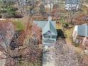 Aerial view of the home showcasing the roof, driveway, and surrounding mature trees at 2418 Summit Dr, Hillsborough, NC 27278