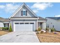 Beautiful single-story home featuring a two-car garage, gray siding, and manicured landscaping at 244 Mahogany Run, Raleigh, NC 27610
