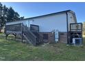 Back of home featuring a back entrance, steps, deck, and exterior utilities at 30 Jamestown Ct Ct, Zebulon, NC 27597