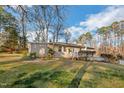 Charming single-story home with a quaint front porch and green lawn surrounded by tall trees at 3012 Optimist Farm Rd, Apex, NC 27539