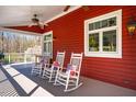 Relaxing covered porch featuring three rocking chairs with colorful pillows, perfect for outdoor living at 3227 Morrow Farm Ln, Chapel Hill, NC 27516