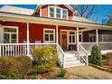 Inviting front porch with white railings, a wooden door, and classic rocking chairs at 3227 Morrow Farm Ln, Chapel Hill, NC 27516