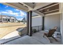 Relaxing covered porch with a comfortable wooden chair, offering a view of the neighborhood and the sky at 3240 Donlin Dr, Wake Forest, NC 27587