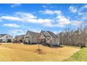 Expansive exterior view of a home with beautiful architectural details set against a clear blue sky and a large lawn at 3240 Donlin Dr, Wake Forest, NC 27587